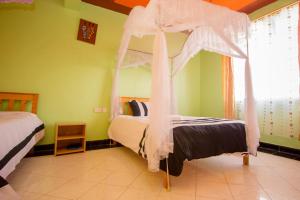 1 dormitorio con 1 cama con dosel en Airport Gate View Hotel, en Nairobi