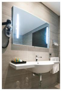 ein Badezimmer mit einem Waschbecken und einem großen Spiegel in der Unterkunft Monteverde Hotel in Beit Meri