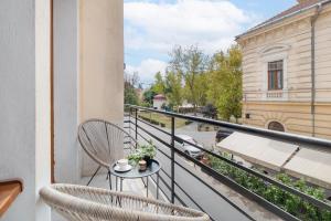 a balcony with two chairs and a table at Oasis Rooms Oradea in Oradea