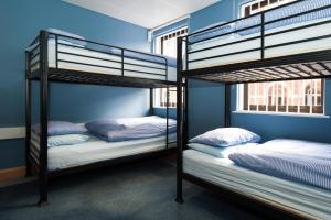 リーズにあるRussell Scott Backpackers Hostelの青い壁の客室で、二段ベッド2台が備わります。
