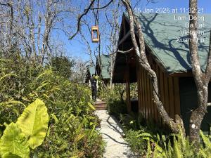 a person walking down a path next to a house at City Dodge Home in Xuan An
