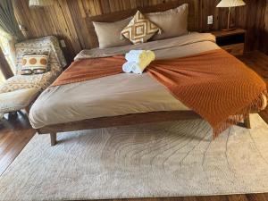 a bed with an orange blanket and towels on it at City Dodge Home in Xuan An
