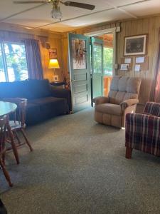 a living room with a couch and chairs and a table at Northwoods Lake Content Cabin in Saint Germain