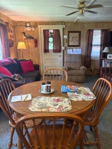 a living room with a wooden table and chairs at Northwoods Lake Content Cabin in Saint Germain