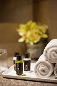 a white tray with three bottles of soap and towels at Click Hotel, Junagadh in Junagadh