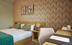 A bed or beds in a room at Click Hotel, Junagadh