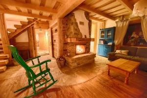 a living room with a stone fireplace and a green chair at Maciejewka in Zahoczewie