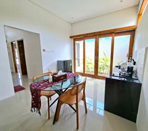 a kitchen and dining room with a table and chairs at Tio Homestay in Praya