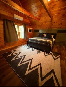 a bedroom with a bed and a rug in a cabin at Cozymountainretreat in Jasper