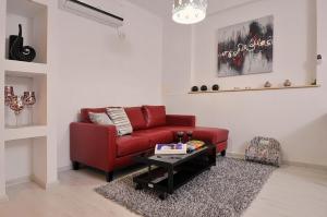 a living room with a red couch and a table at Sharvit Hakesem in Livnim