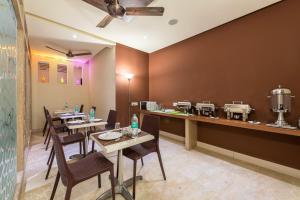 un restaurante con mesas, sillas y una barra en Treebo Trend Nestlay Casa, en Chennai