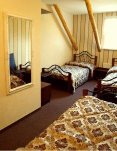 a hotel room with two beds and a mirror at Buožinta in Buožėnai