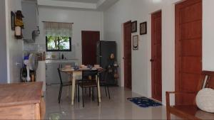 a kitchen with a table and a kitchen with a refrigerator at Secluded, Modern, Minimalist house - Gray House in Dampalan