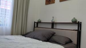 a bedroom with a bed with two pillows on it at Secluded, Modern, Minimalist house - Gray House in Dampalan