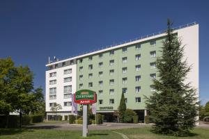 a hotel with a sign in front of a building at Courtyard by Marriott Toulouse Airport in Toulouse