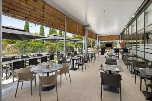 a restaurant with tables and chairs and windows at Courtyard by Marriott Toulouse Airport in Toulouse
