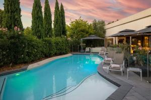 a swimming pool with chairs and a building at Courtyard by Marriott Toulouse Airport in Toulouse
