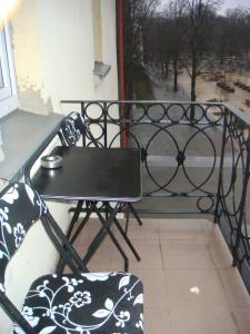 a table and chair on a balcony with a view at M. Mažvydo al. butas in Klaipėda