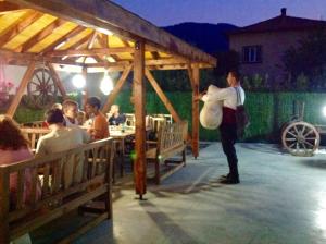 a man standing in front of a restaurant at night at Hotel Alikante in Sarnitsa