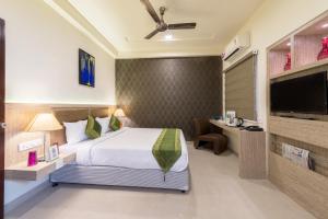a hotel room with a bed and a flat screen tv at Treebo Trend Nestlay Casa in Chennai