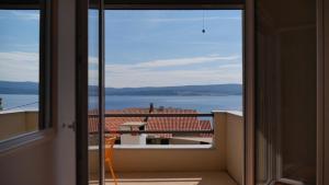 a room with a view of the ocean from a balcony at Villa Marina in Omiš