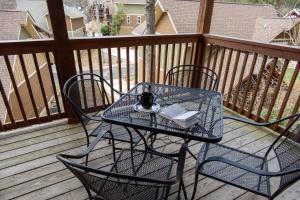 a table and chairs on a balcony with a book at Sweet Serenity in Gatlinburg