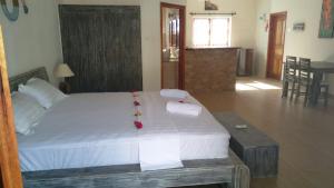 a bedroom with a large bed with towels on it at Coral Apartments in La Digue