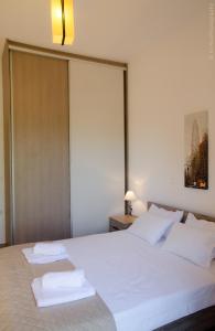Epáno KefalásにあるVilla Sunriseのベッドルーム1室(白いベッド1台、タオル2枚付)