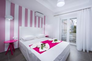a bedroom with a white bed with flowers on it at La central Apartments in Limenaria