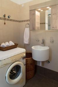 a bathroom with a washing machine and a sink at Villa Sunrise in Epáno Kefalás