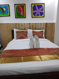 ein Bett mit einem Paar Schuhen darauf in der Unterkunft DBuilders Rooms Hotel in Sampong