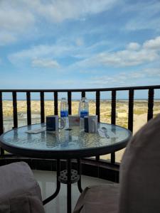 a table on a balcony with a view of the beach at Ras Al Hadd Guest House in Al Ḩadd