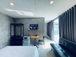 a bedroom with a bed and a desk with a computer at Udomsuk Inn & Cafe - BTS Udomsuk in Bangkok