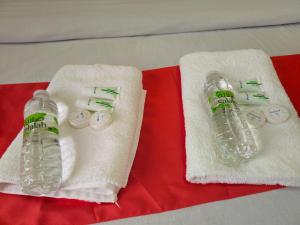 two towels and two water bottles on a table at Ras Al Hadd Guest House in Al Ḩadd