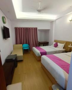 a hotel room with two beds and a chair at Best Southern Hotel in Kuākāta