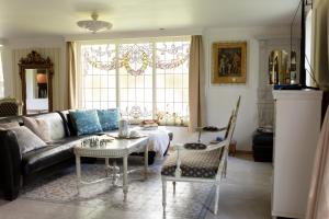 a living room with a couch and a table at Petit Château luxe vakantiehuis, prive hottub en zwembad in Heythuysen