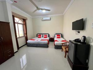 a room with two beds and a flat screen tv at Ras Al Hadd Guest House in Al Ḩadd +51 photos