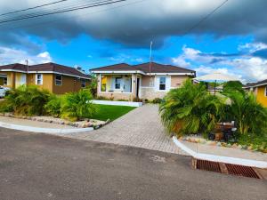 a house with palm trees in front of a driveway at The Surada Bay in Old Harbour