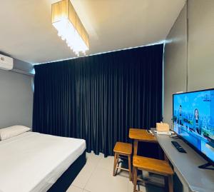 a bedroom with a bed and a desk with a computer at Udomsuk Inn & Cafe - BTS Udomsuk in Bangkok