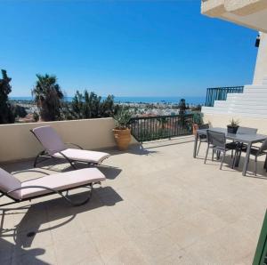 a patio with chairs and a table on a balcony at PJ's Apartment, Paphos, Cyprus in Khlorakas