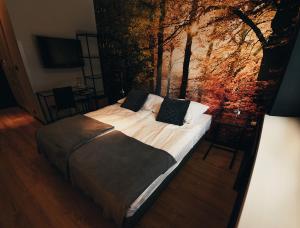 a bedroom with a bed with a painting on the wall at Hotel Szablewski in Dymaczewo Nowe