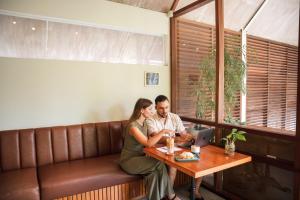 a man and a woman sitting at a table with a laptop at Ecozy Dijiwa Canggu in Canggu