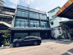a black car parked in front of a building at Udomsuk Inn & Cafe - BTS Udomsuk in Bangkok