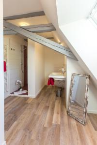 ein Badezimmer mit einem Spiegel und einem Waschbecken im Dachgeschoss in der Unterkunft Artem Orbis in Jena