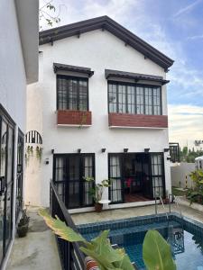 a house with a swimming pool in front of it at Serenita Tagaytay in Kibagan