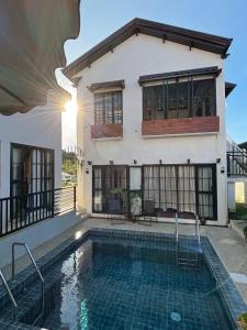 a house with a swimming pool in front of a house at Serenita Tagaytay in Kibagan