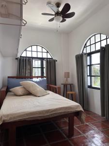 a bedroom with a bed with a ceiling fan at Serenita Tagaytay in Kibagan +26 photos