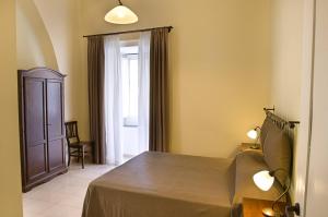 a bedroom with a bed and a chair and a window at Il Guiscardo B&B in Salerno