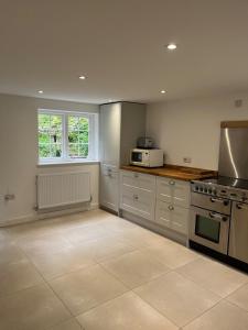 a kitchen with a stove and a microwave at 3 bedroom remote rural idyll on the North Downs in Faversham +12 photos