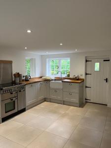 a large kitchen with a sink and a stove at 3 bedroom remote rural idyll on the North Downs in Faversham